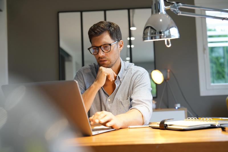 un homme entrain de travailler devant son ordinateur